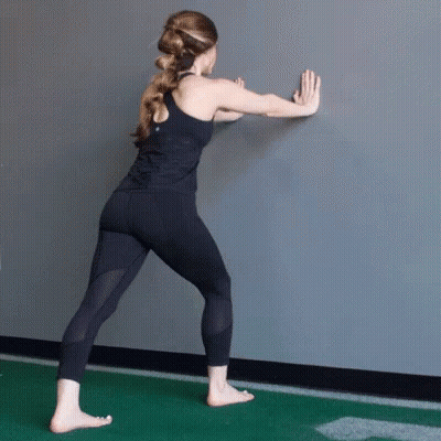 Woman In Black Tank Top Sitting On Gym Floor In Front Of Mirror GIF