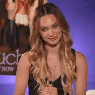 Woman In Black Tank Top Smiling In Front Of Each Now Poster GIF