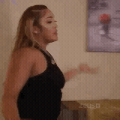 Woman In Black Tank Top Standing In Front Of Painting GIF