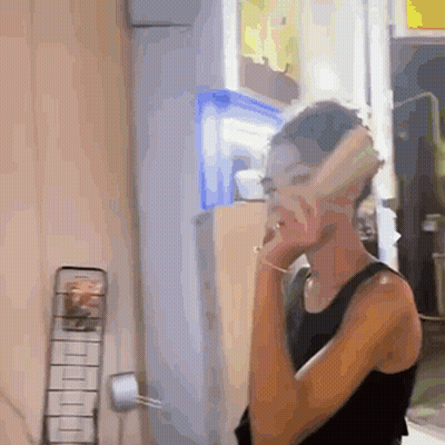 Woman In Black Tank Top Talking On Phone GIF