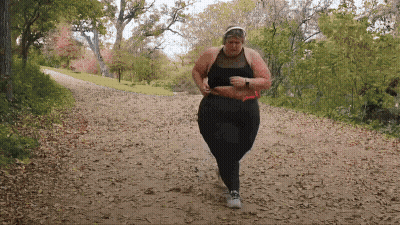 Woman In Black Top And Pants Running Down Dirt Path GIF