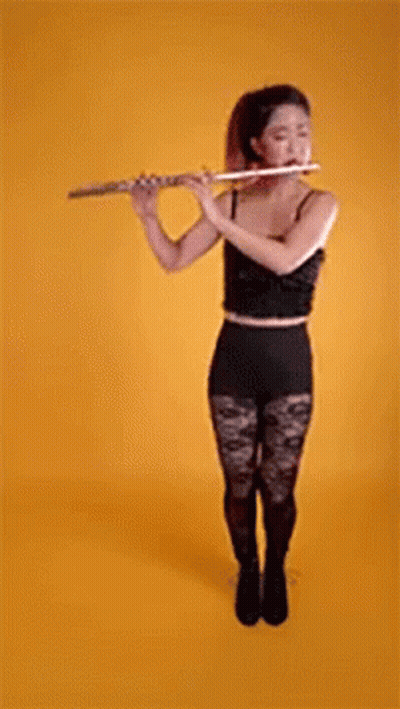 Woman in Black Top and Tights Playing Flute