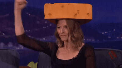 Woman In Black Top Holding Cheese On Head GIF