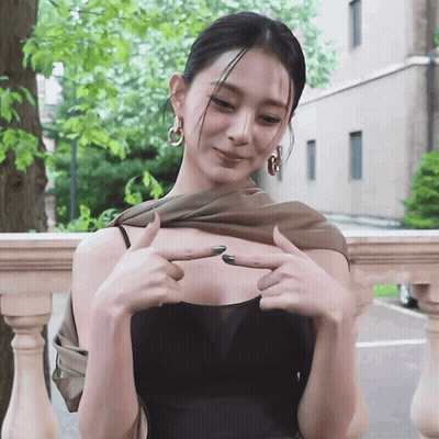 Woman In Black Top Pointing At Breast GIF