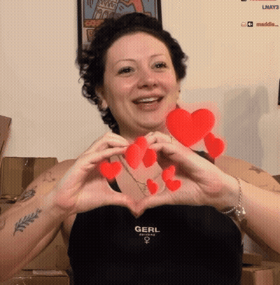 Woman In Black Top Saying Gerl Making Heart Shape GIF