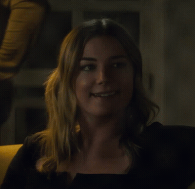 Woman In Black Top Smiling Looking To Side GIF
