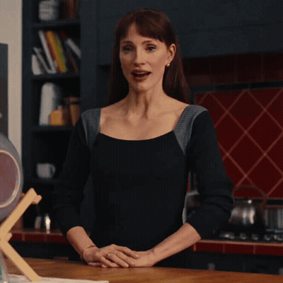 Woman In Black Top Standing In Kitchen With Hands Folded GIF