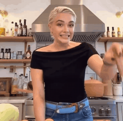 Woman In Black Top With Pot In Kitchen GIF
