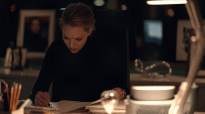 Woman In Black Turtleneck Writing At Desk GIF