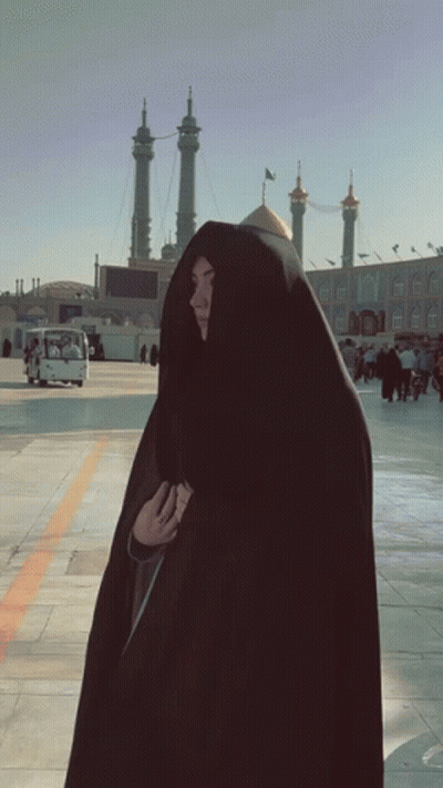 Woman In Black Veil Standing Before Building GIF