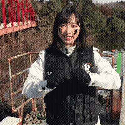 Woman In Black Vest With Letter V Smiling GIF