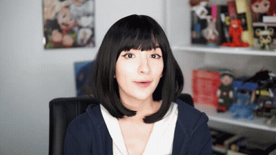 Woman In Black Wig And Blue Hoodie Looking At Camera GIF