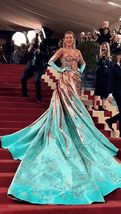 Woman In Blue And Gold Dress Walking Down Stairs GIF