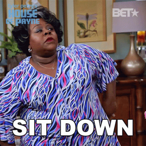 Woman In Blue And Pink Zebra Dress Standing In Front Of Sit Down Sign GIF