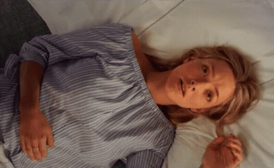 Woman In Blue And White Striped Shirt Laying On Bed GIF