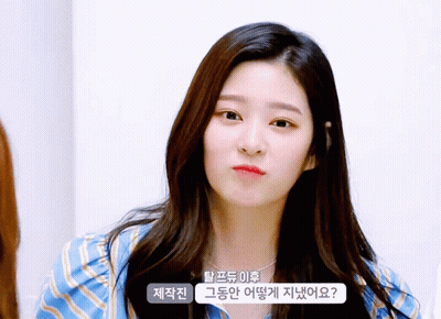 Woman In Blue And White Striped Shirt Looks At Camera GIF