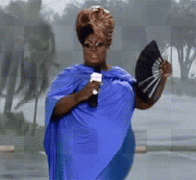 Woman In Blue Cape Holding Fan And Microphone GIF