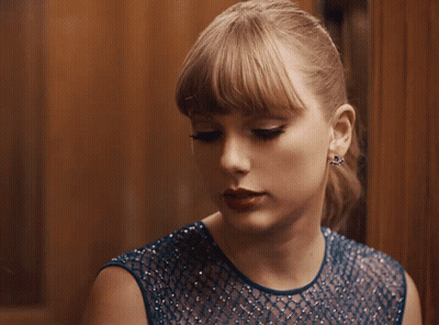 Woman In Blue Dress And Earrings Looking Down GIF