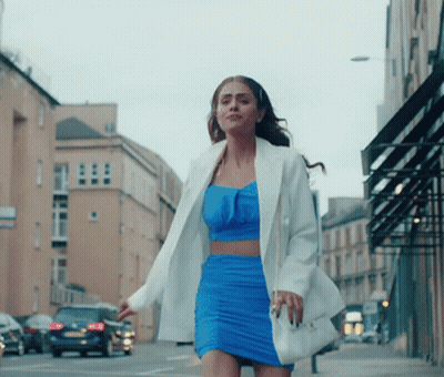 Woman In Blue Dress And White Jacket Walking GIF