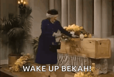 Woman In Blue Dress Beside Coffin With Flowers GIF
