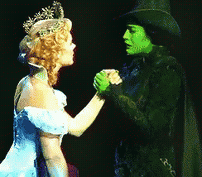 Woman In Blue Dress Holding Hands With Green Woman GIF
