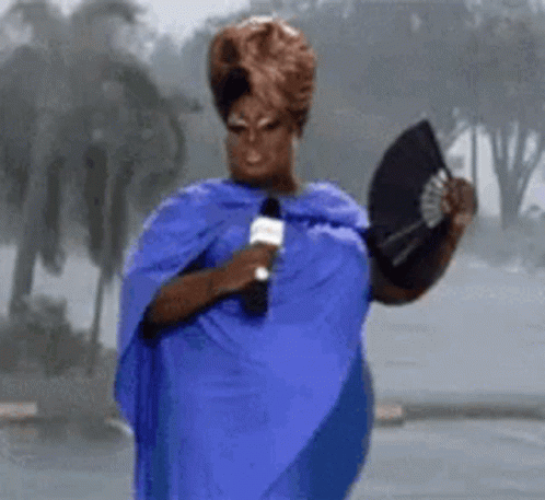 Woman In Blue Dress Holding Microphone And Fan GIF