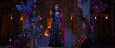 Woman In Blue Dress In Front Of Flowers GIF
