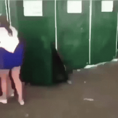 Woman In Blue Dress In Front Of Green Stalls GIF