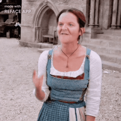 Woman In Blue Dress In Front Of Stone Building GIF
