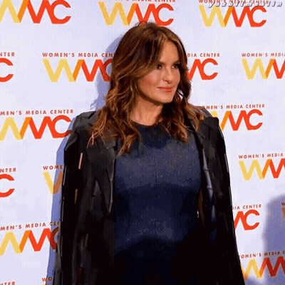 Woman In Blue Dress In Front Of Wall Saying Women's Media Center GIF