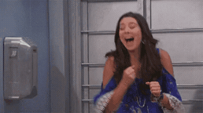 Woman In Blue Dress Laughing And Pumping Fist GIF