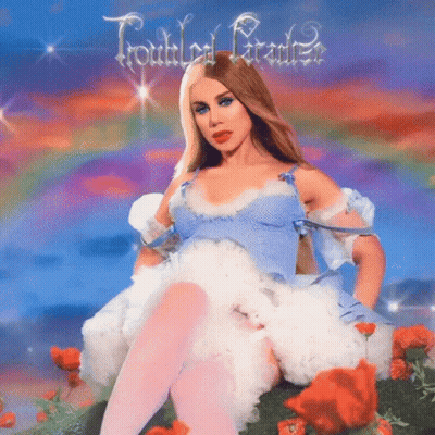 Woman In Blue Dress Sitting In Flower Field GIF