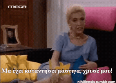 Woman In Blue Dress Sitting On Pink Couch With Mega Logo GIF