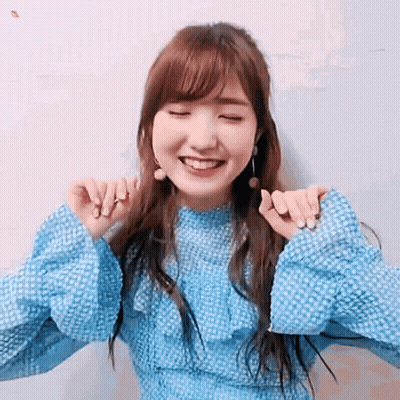 Woman In Blue Dress Smiling With Eyes Closed And Hands On Neck GIF