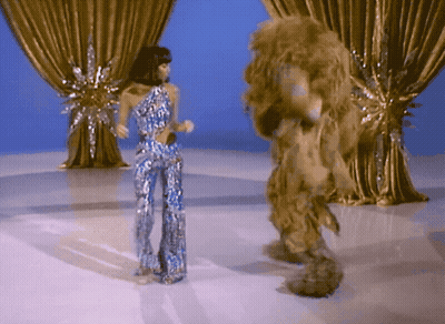 Woman In Blue Dress Standing Before Crowd GIF