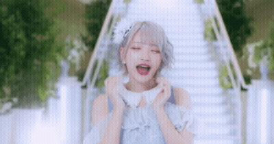 Woman In Blue Dress Standing In Front Of Stairs With Mouth Open GIF