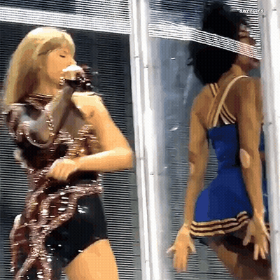 Woman In Blue Dress Standing Next To Woman In Red Dress GIF