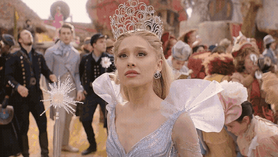Woman In Blue Dress With Crown Standing In Front Of Crowd GIF