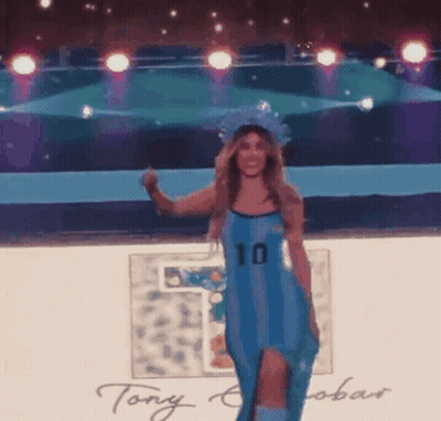Woman In Blue Dress With Number 10 Walking On Stage GIF
