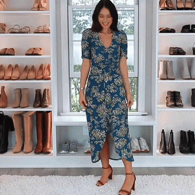 Woman In Blue Floral Dress Standing In Front Of Window GIF
