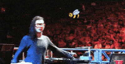 Woman In Blue Hoodie Standing Before Crowd With Bee GIF