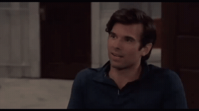 Woman In Blue Jacket And Earrings Making Face GIF