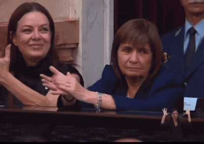 Woman In Blue Jacket Beside Woman In Black Dress GIF