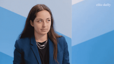 Woman In Blue Jacket By Blue Wall With Elite Daily GIF