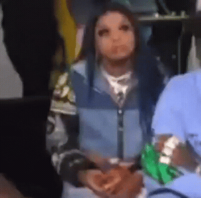 Woman In Blue Jacket Holding Green Bag Of Money In Crowd GIF