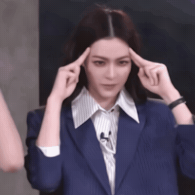 Woman In Blue Jacket Holding Hands To Head GIF