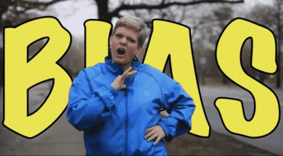 Woman In Blue Jacket In Front Of Bias Sign GIF