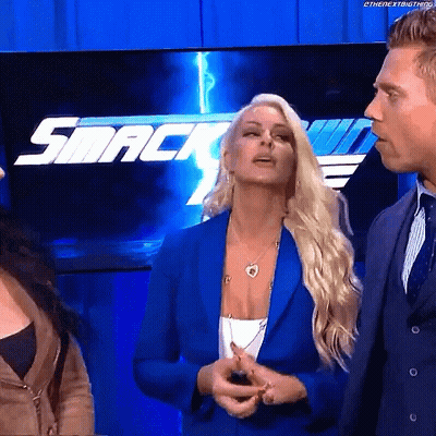 Woman In Blue Jacket In Front Of SmackDown Logo GIF