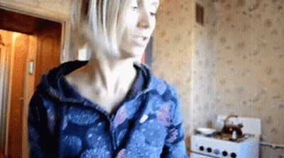 Woman In Blue Jacket In Kitchen GIF