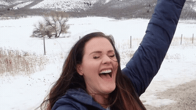 Woman In Blue Jacket Laughing Arms Up GIF